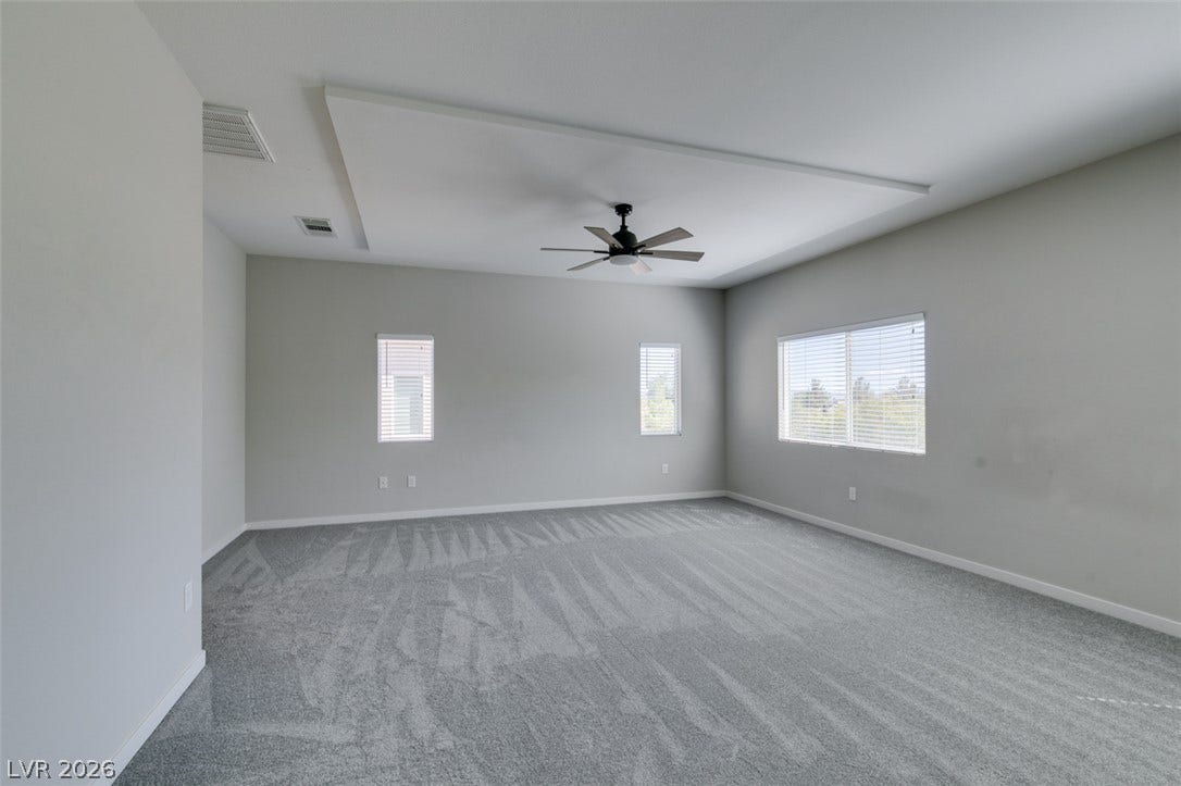 Plush carpeting underfoot complements the architectural tray ceiling in this quiet retreat.