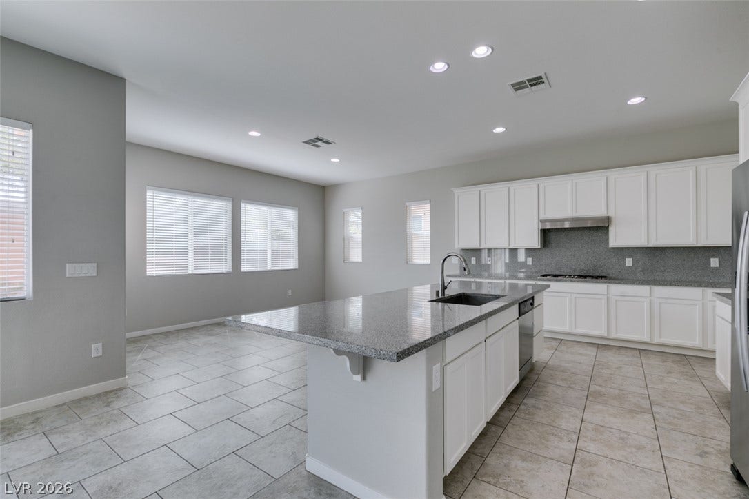 Gleaming tile floors and granite countertops define this modern, open-concept kitchen.