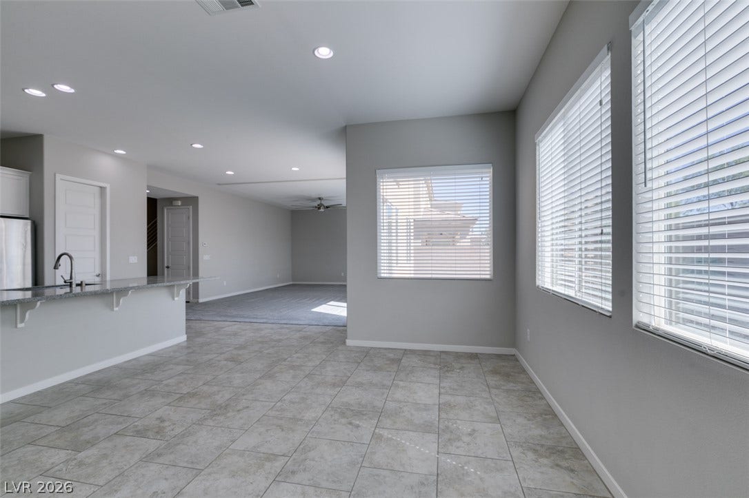 Tiled floors and recessed lighting enhance this open-concept layout with generous natural window light.