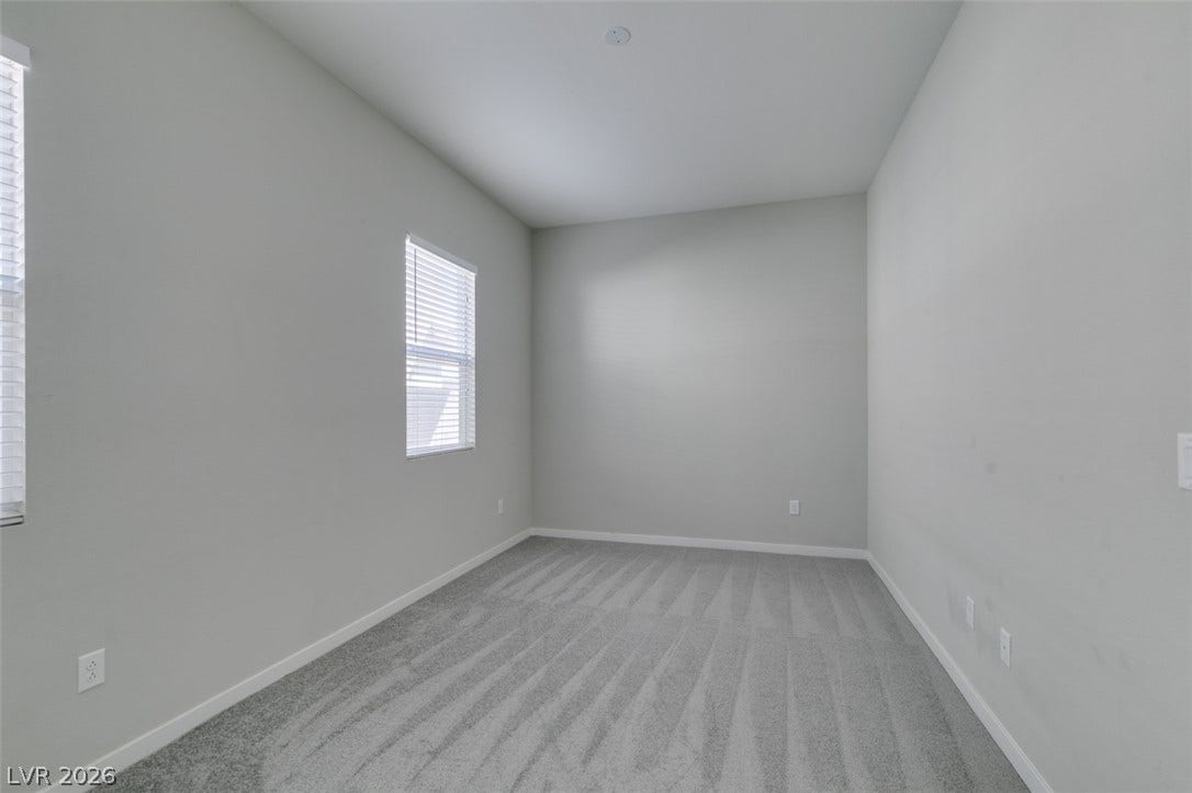 Clean lines and soft carpeting define this versatile, neutrally finished bedroom space.