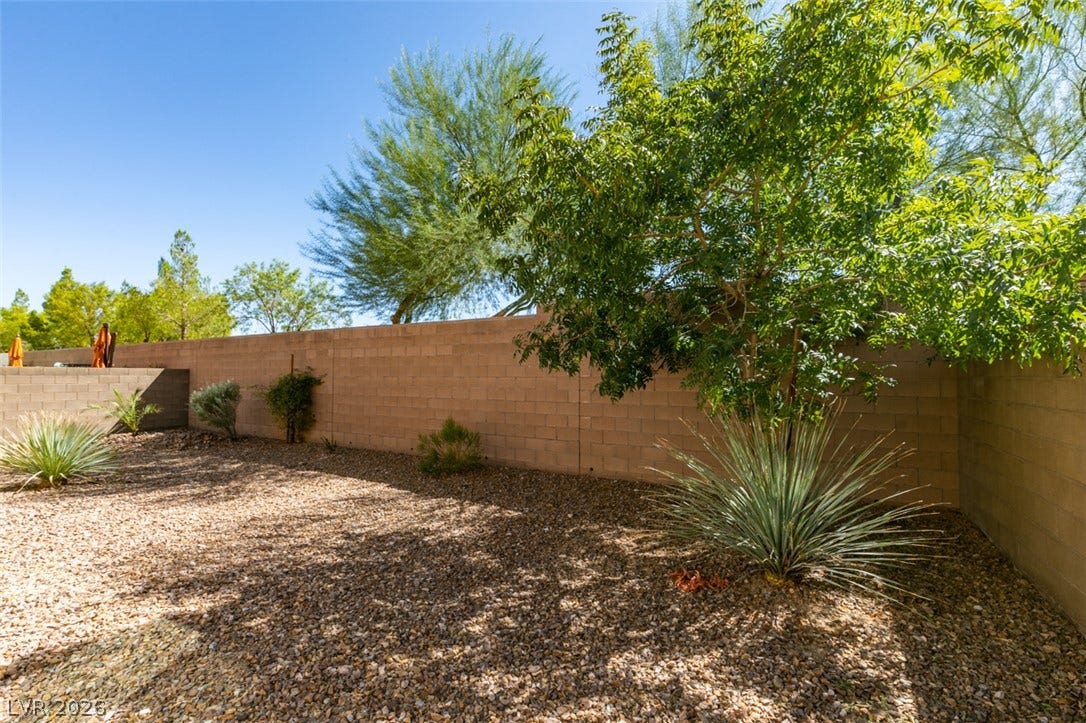 Mature trees and low-maintenance desert landscaping fill this private enclosed outdoor space.