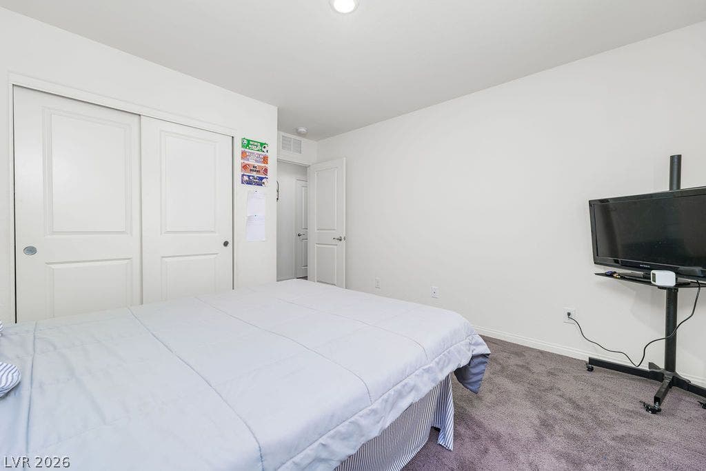 6135 Larimar Gold Street, North Las Vegas, NV 89115 Plush carpeting underfoot and ample closet storage define this serene bedroom retreat.