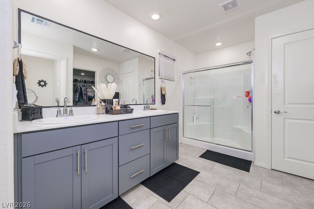6135 Larimar Gold Street, North Las Vegas, NV 89115 Clean tile flooring and a double vanity define this modern, functional bathroom space.
