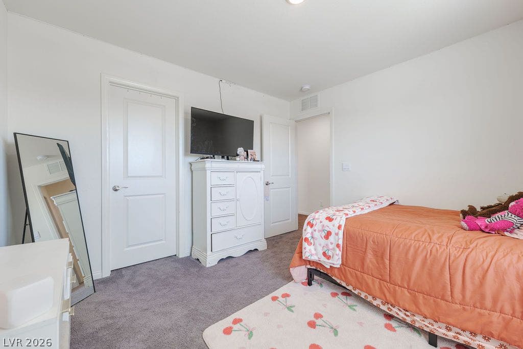 6135 Larimar Gold Street, North Las Vegas, NV 89115 Plush carpeting and crisp white walls create a quiet and inviting bedroom setting.
