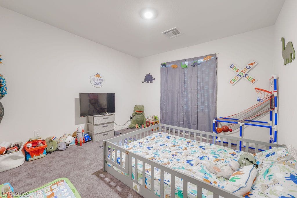 6135 Larimar Gold Street, North Las Vegas, NV 89115 Plush carpeting and a wide window define this cozy secondary bedroom.