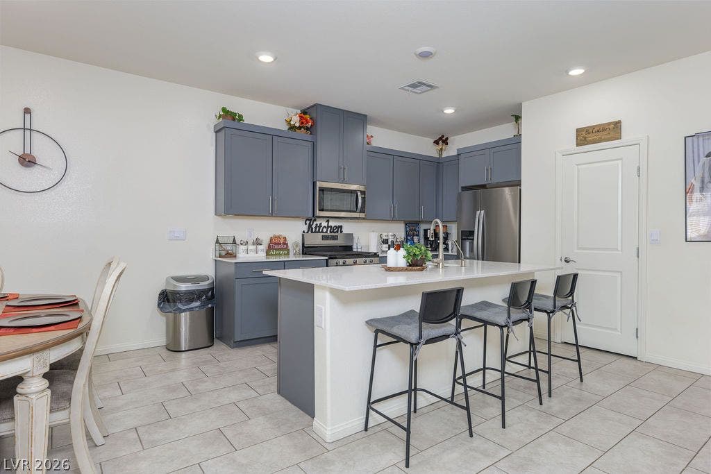 6135 Larimar Gold Street, North Las Vegas, NV 89115 Gleaming stone countertops and a spacious breakfast island anchor this contemporary kitchen design.