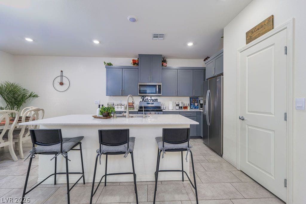 6135 Larimar Gold Street, North Las Vegas, NV 89115 An inviting kitchen features tile flooring and a central island with a breakfast bar.