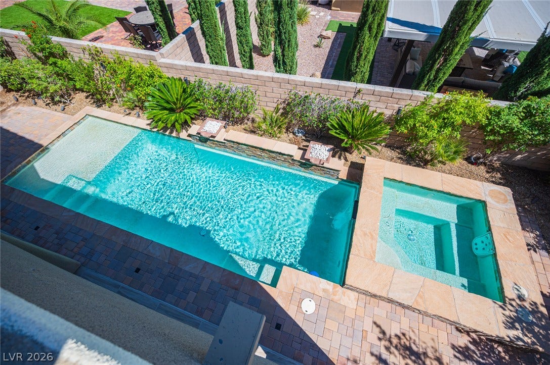 322 Elder View Drive, Las Vegas, NV 89138 A sparkling geometric pool and integrated spa sit surrounded by neat stone paving and lush landscaping.