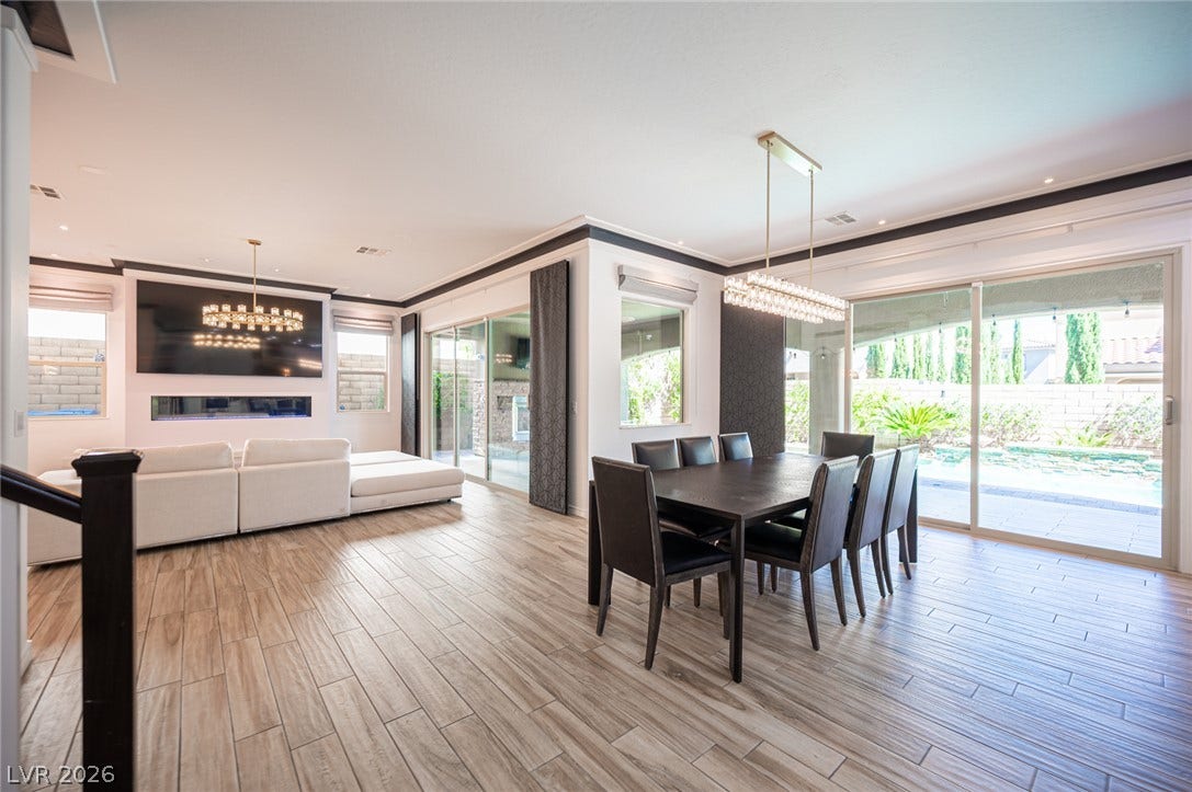 322 Elder View Drive, Las Vegas, NV 89138 Sliding glass doors connect the expansive open-concept living and dining spaces to the poolside patio.