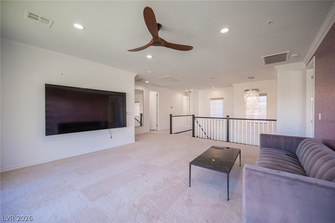 322 Elder View Drive, Las Vegas, NV 89138 Crown molding and soft carpeting elevate this upper-level living space.