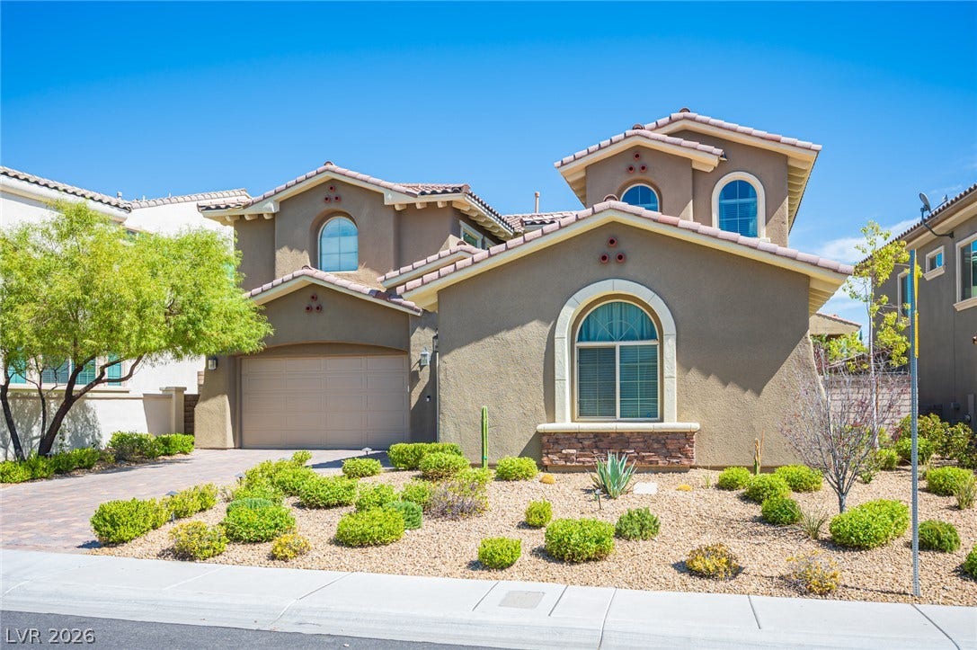 322 Elder View Drive, Las Vegas, NV 89138 Spanish tile roofing and arched window details highlight this multi-level stucco residence.