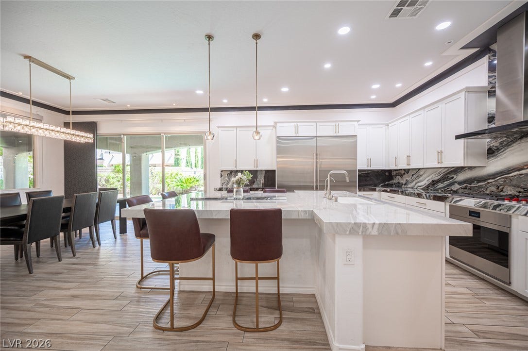 322 Elder View Drive, Las Vegas, NV 89138 Polished tile flooring flows through this bright, open kitchen featuring a massive stone island.