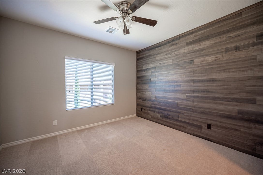 322 Elder View Drive, Las Vegas, NV 89138 Plush carpeting underfoot complements a textured wood-paneled feature wall and single bright window.