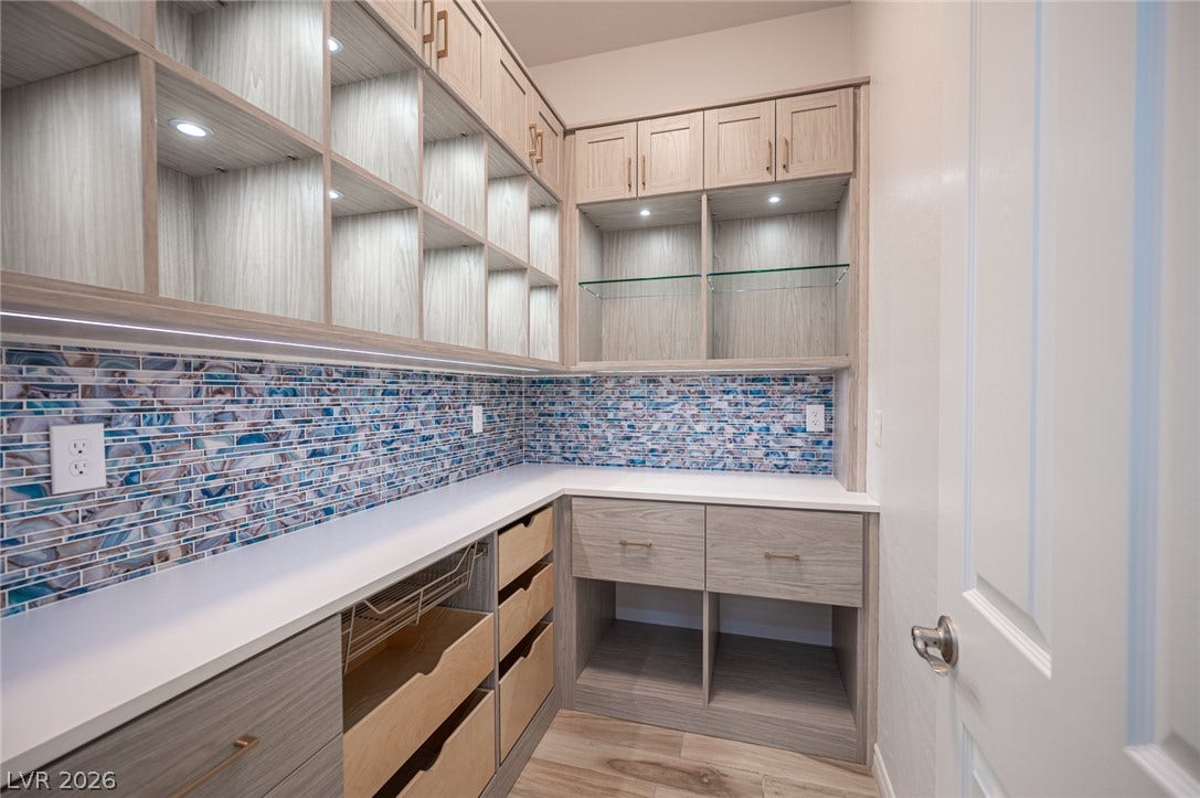 322 Elder View Drive, Las Vegas, NV 89138 Custom cabinetry and vibrant glass tile backsplash maximize storage and style in this walk-in pantry.