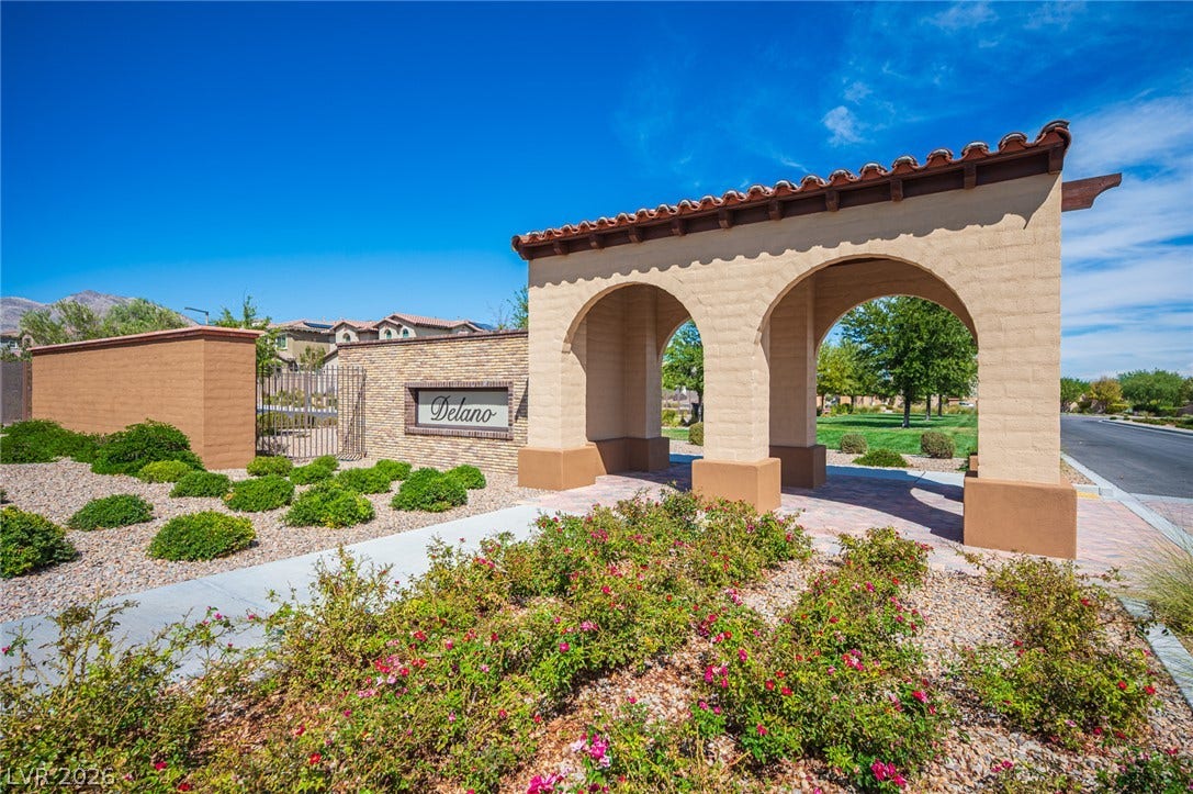 322 Elder View Drive, Las Vegas, NV 89138 An arched entry structure with tile roofing stands amidst manicured desert landscaping.