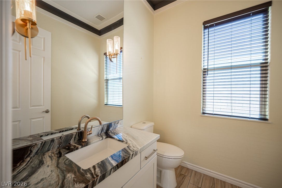 322 Elder View Drive, Las Vegas, NV 89138 Ornate stone counters and dark crown molding elevate this charming half bathroom.
