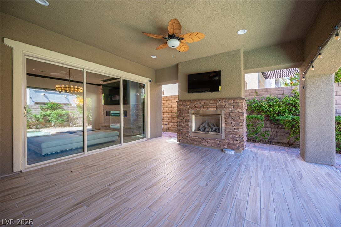 322 Elder View Drive, Las Vegas, NV 89138 An inviting stone fireplace anchors this covered outdoor space finished with durable tile flooring.