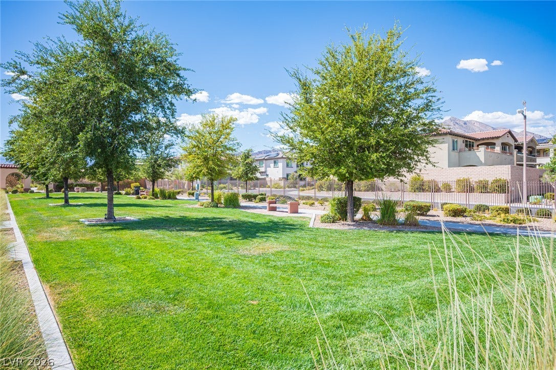322 Elder View Drive, Las Vegas, NV 89138 Mature shade trees and a manicured green lawn border a paved walking path.