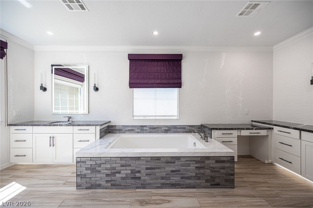 322 Elder View Drive, Las Vegas, NV 89138 A deep soaking tub serves as the centerpiece of this modern bathroom with wood-look tile floors.