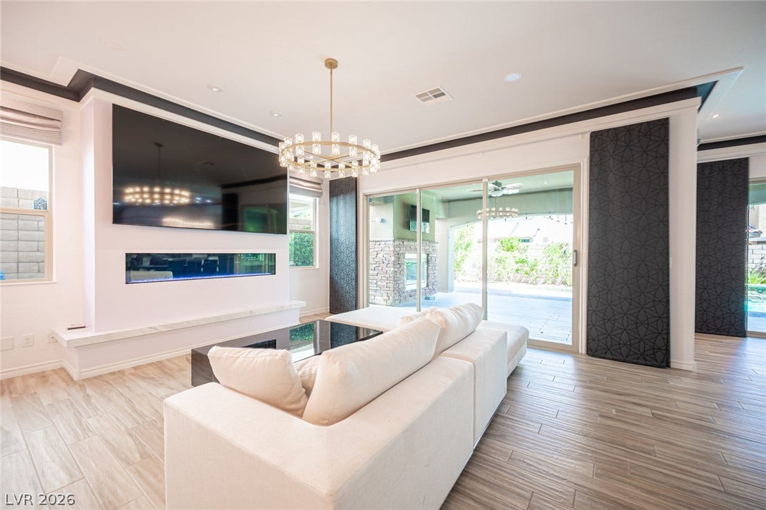 322 Elder View Drive, Las Vegas, NV 89138 Glazed sliding doors frame patio views from this contemporary living space with wood-look tile floors.