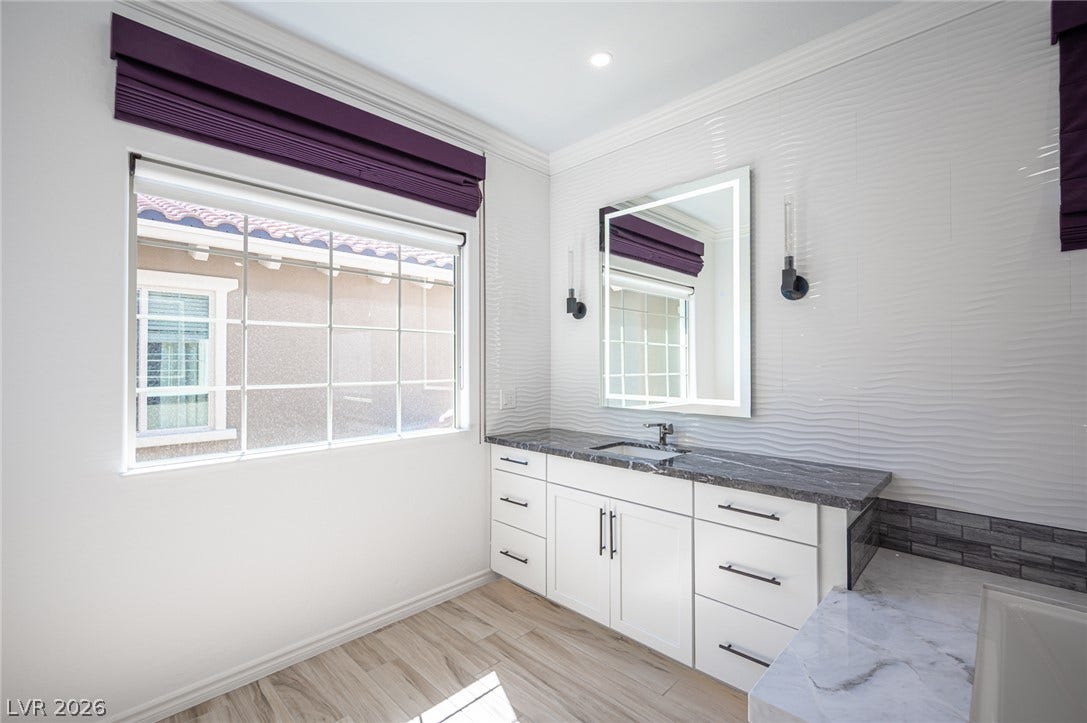 322 Elder View Drive, Las Vegas, NV 89138 High ceilings and clean crown molding frame this modern bathroom with a stone-counter vanity.