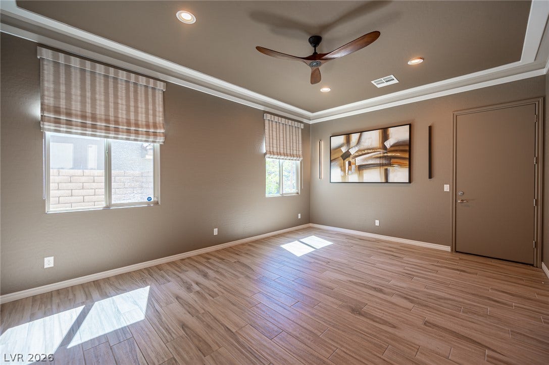 322 Elder View Drive, Las Vegas, NV 89138 Gleaming wood-look tile flooring and a tray ceiling define this versatile living space.