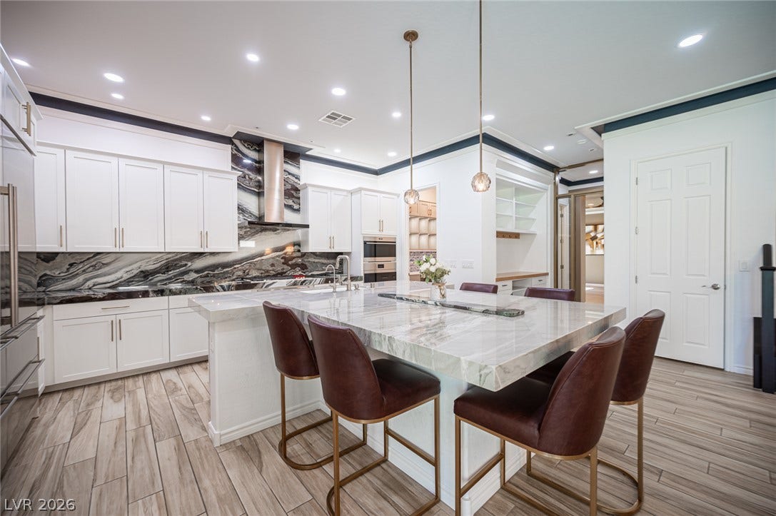 322 Elder View Drive, Las Vegas, NV 89138 Gleaming stone countertops and matching backsplash slabs elevate this modern culinary workspace.