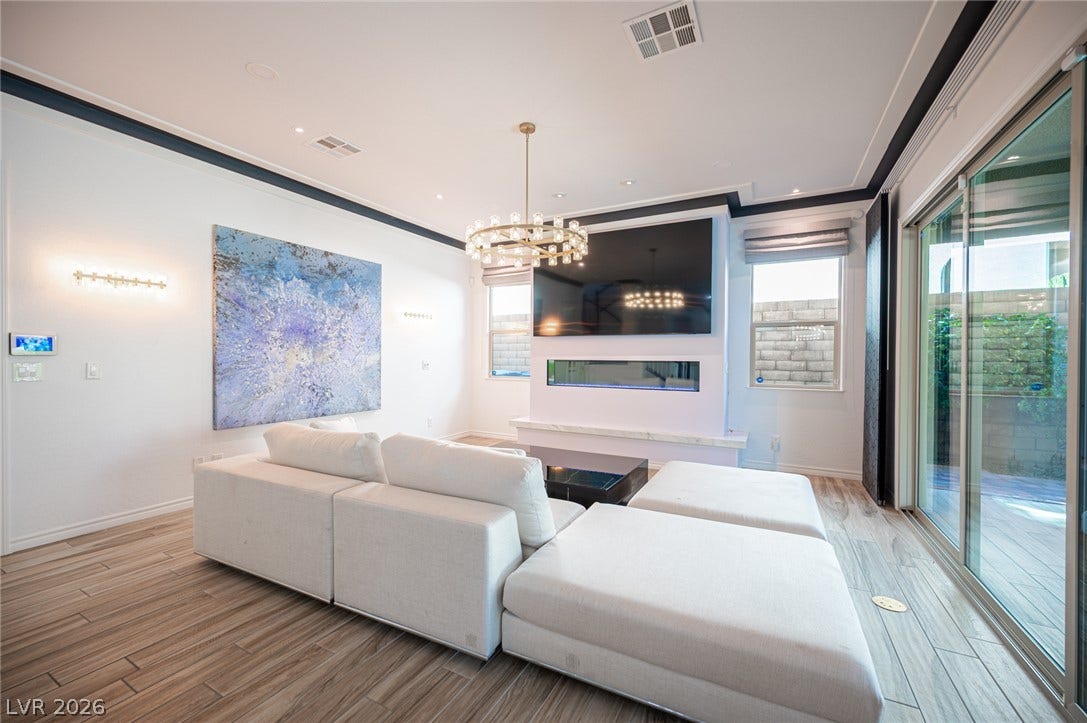 322 Elder View Drive, Las Vegas, NV 89138 Sliding glass doors open to the outdoors from this modern living space with wood-look tile floors.
