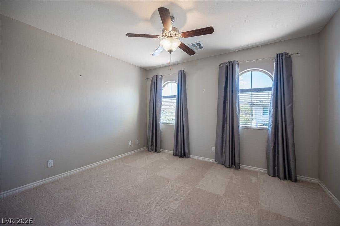 322 Elder View Drive, Las Vegas, NV 89138 Arched windows and plush carpeting define this versatile secondary bedroom space.