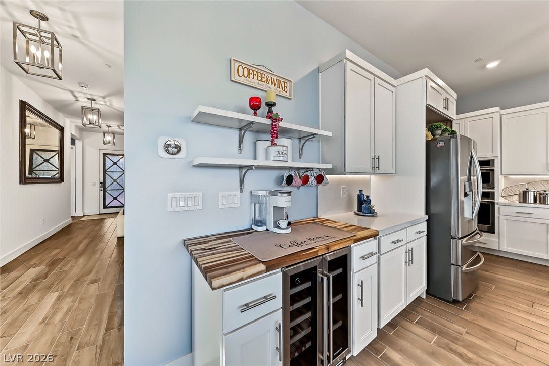 Gleaming wood-look floors pair beautifully with crisp shaker cabinetry and sleek stone countertops.