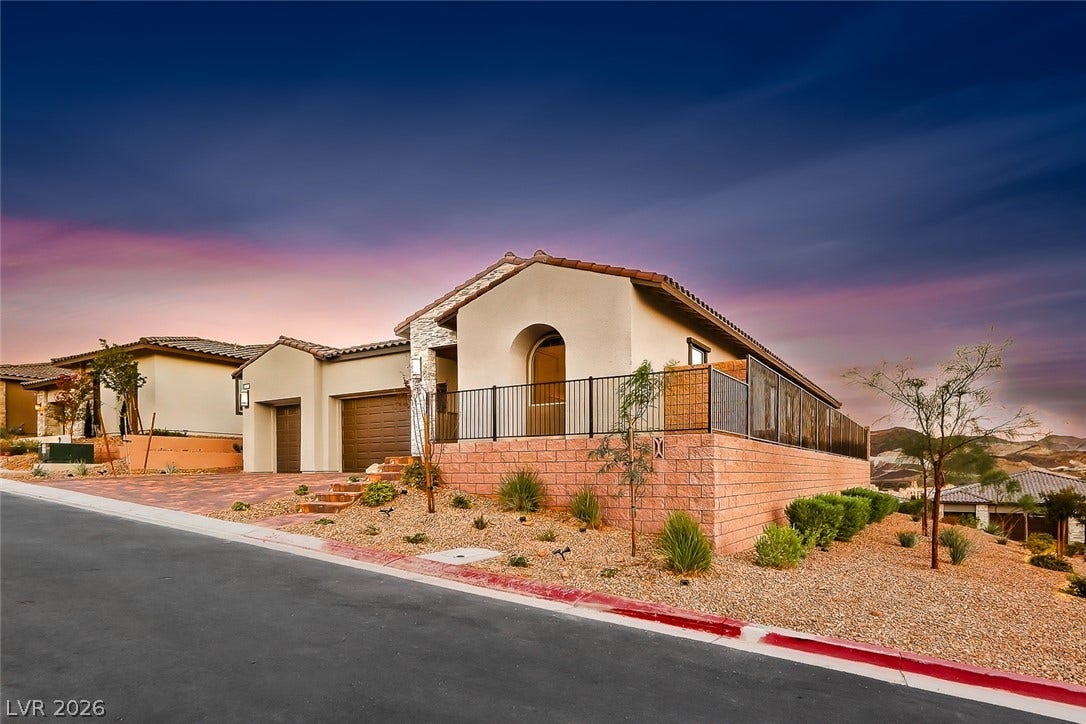 Spanish-inspired architecture highlights this elevated corner lot home with low-maintenance desert landscaping.
