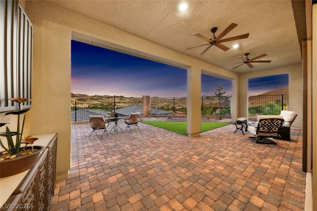 An inviting covered patio paved in brick offers scenic mountain views.