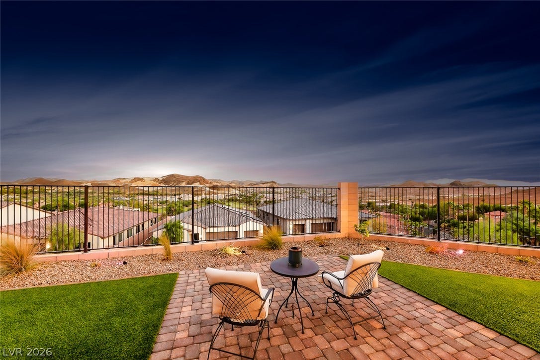 Panoramic mountain views highlight this elevated backyard retreat with paver stone hardscaping.