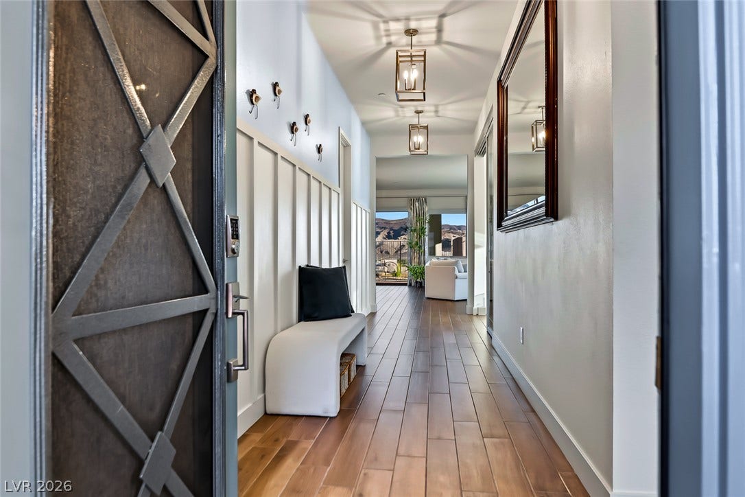 An inviting hallway showcases classic board and batten paneling alongside rich wood flooring.