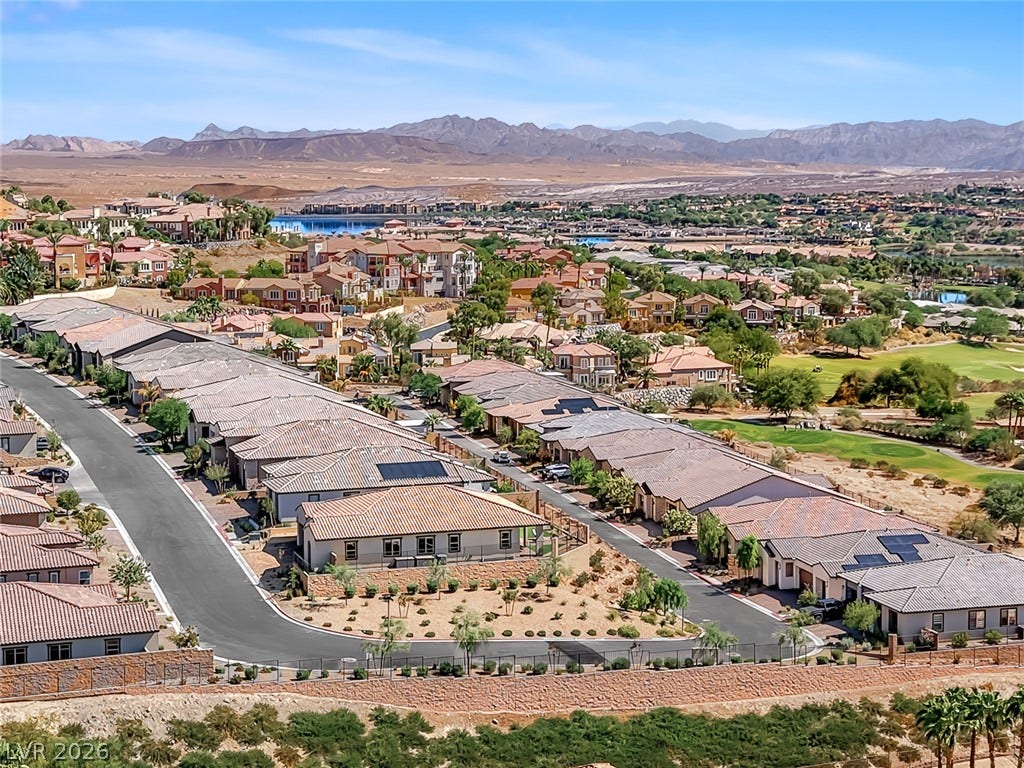Distant mountains frame a desert valley neighborhood bordered by a green golf course.
