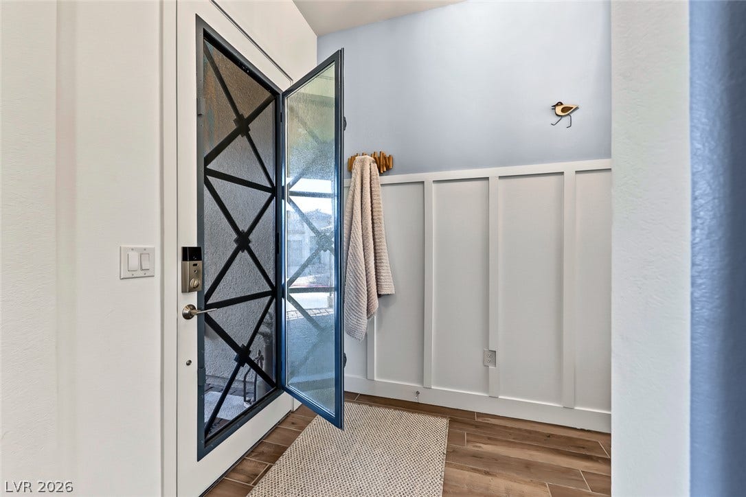 Board and batten paneling details an inviting entry featuring durable wood-look tile flooring.