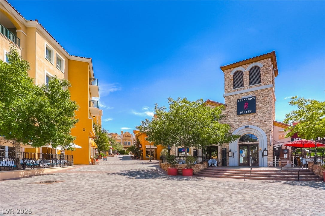 Mediterranean-inspired stone facades and paved pathways define this vibrant pedestrian village plaza.