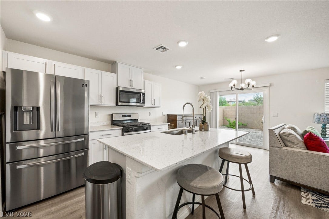 5651 Scarlet Rock Street, North Las Vegas, NV 89081 Granite counters and white cabinetry define this modern kitchen with sliding doors to the patio.