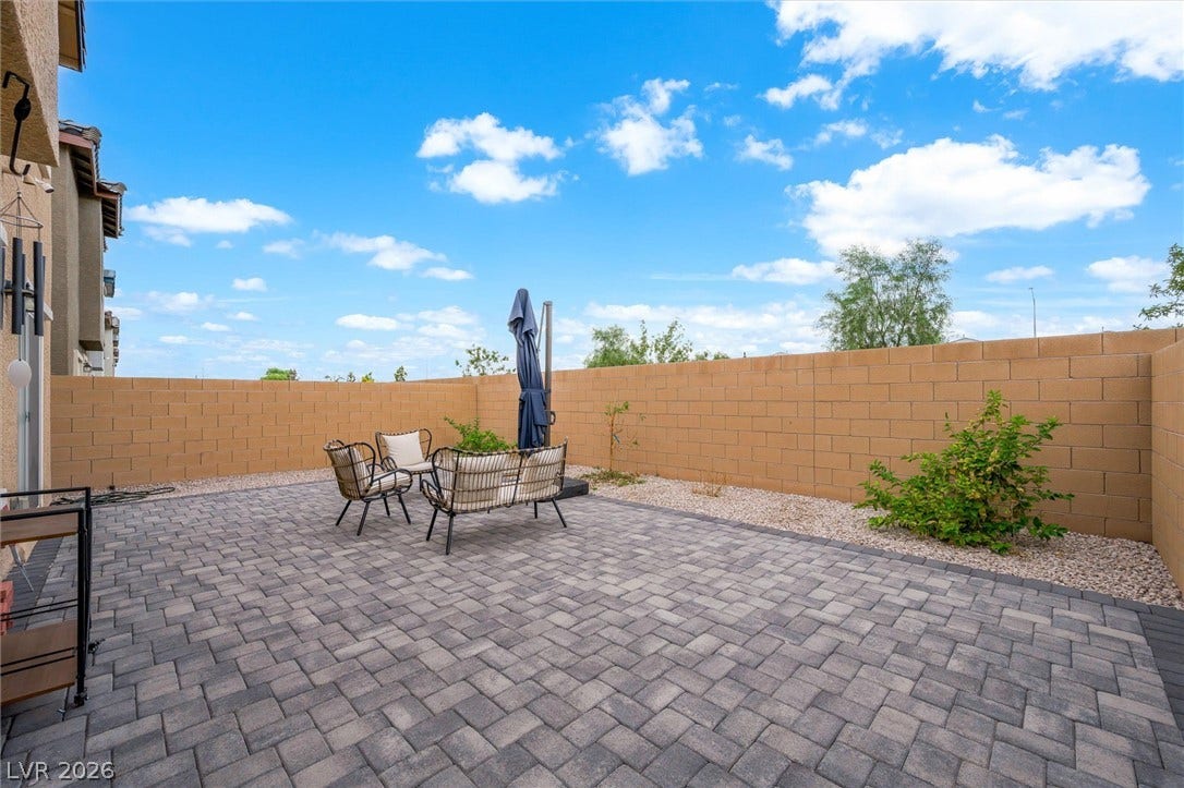 5651 Scarlet Rock Street, North Las Vegas, NV 89081 An expansive paver patio sits enclosed within high privacy block walls under blue skies.