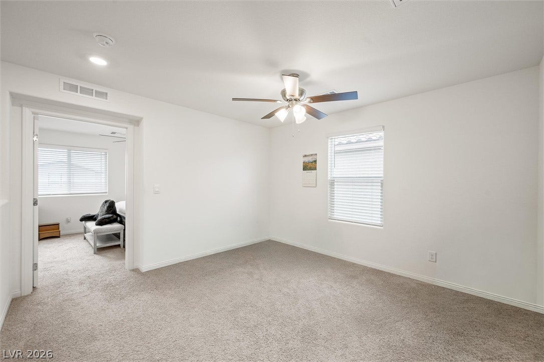 5651 Scarlet Rock Street, North Las Vegas, NV 89081 A spacious secondary bedroom features clean white walls and soft wall-to-wall carpeting.