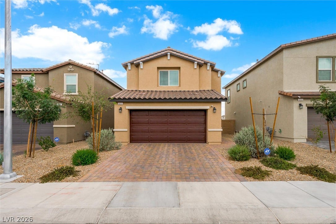 5651 Scarlet Rock Street, North Las Vegas, NV 89081 A classic stucco exterior features a paved driveway leading to a spacious two-car garage.