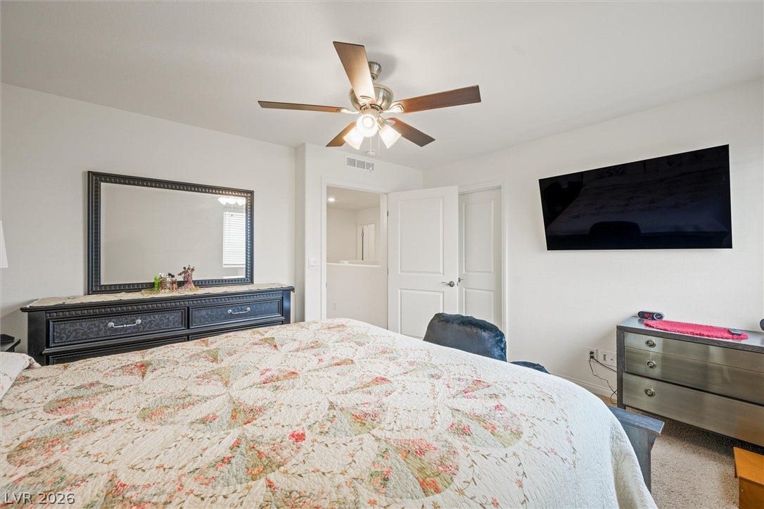 5651 Scarlet Rock Street, North Las Vegas, NV 89081 Comfortable bedroom space featuring soft carpeting and clean white walls throughout.