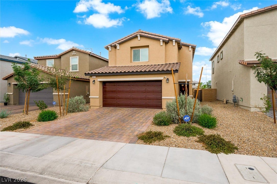 5651 Scarlet Rock Street, North Las Vegas, NV 89081 Spanish tile roofing and a paved driveway enhance this classic stucco exterior.