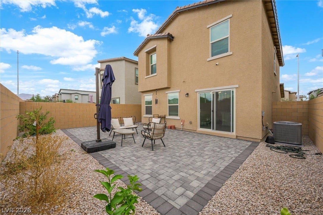 5651 Scarlet Rock Street, North Las Vegas, NV 89081 An inviting backyard patio features neat paver stone flooring surrounded by a secure stone wall.
