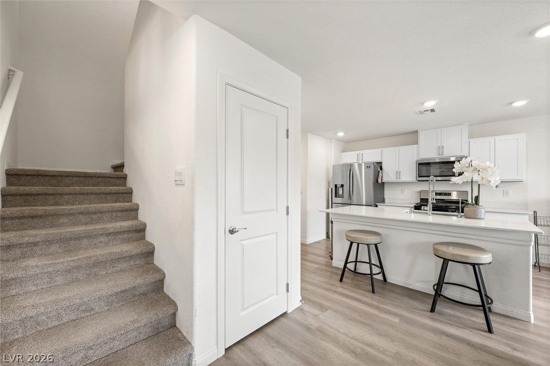 5651 Scarlet Rock Street, North Las Vegas, NV 89081 An open floor plan connects the kitchen island to the carpeted staircase.
