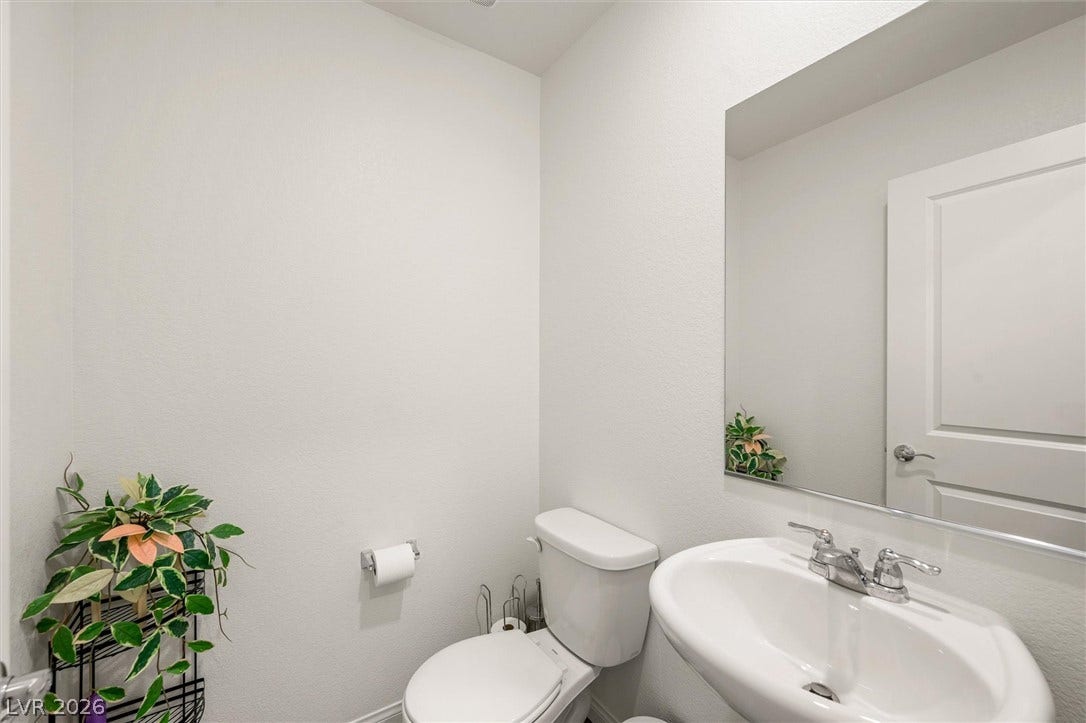 5651 Scarlet Rock Street, North Las Vegas, NV 89081 A pedestal sink paired with a large mirror defines this crisp half-bath layout.