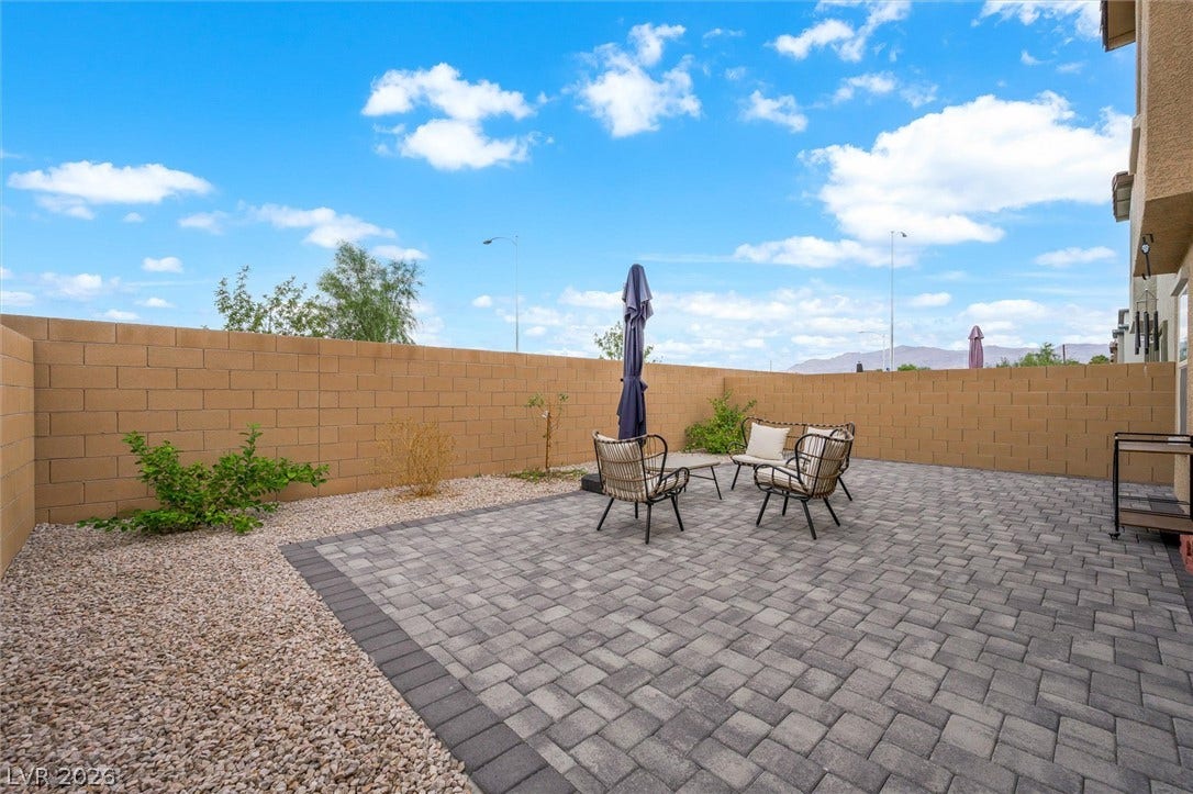 5651 Scarlet Rock Street, North Las Vegas, NV 89081 An inviting paved patio sits enclosed by a substantial block wall under blue skies.