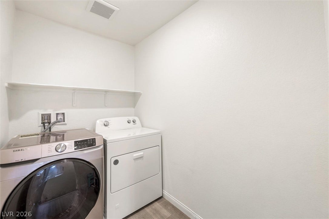 5651 Scarlet Rock Street, North Las Vegas, NV 89081 A dedicated laundry space features clean walls, vinyl flooring, and built-in shelving.