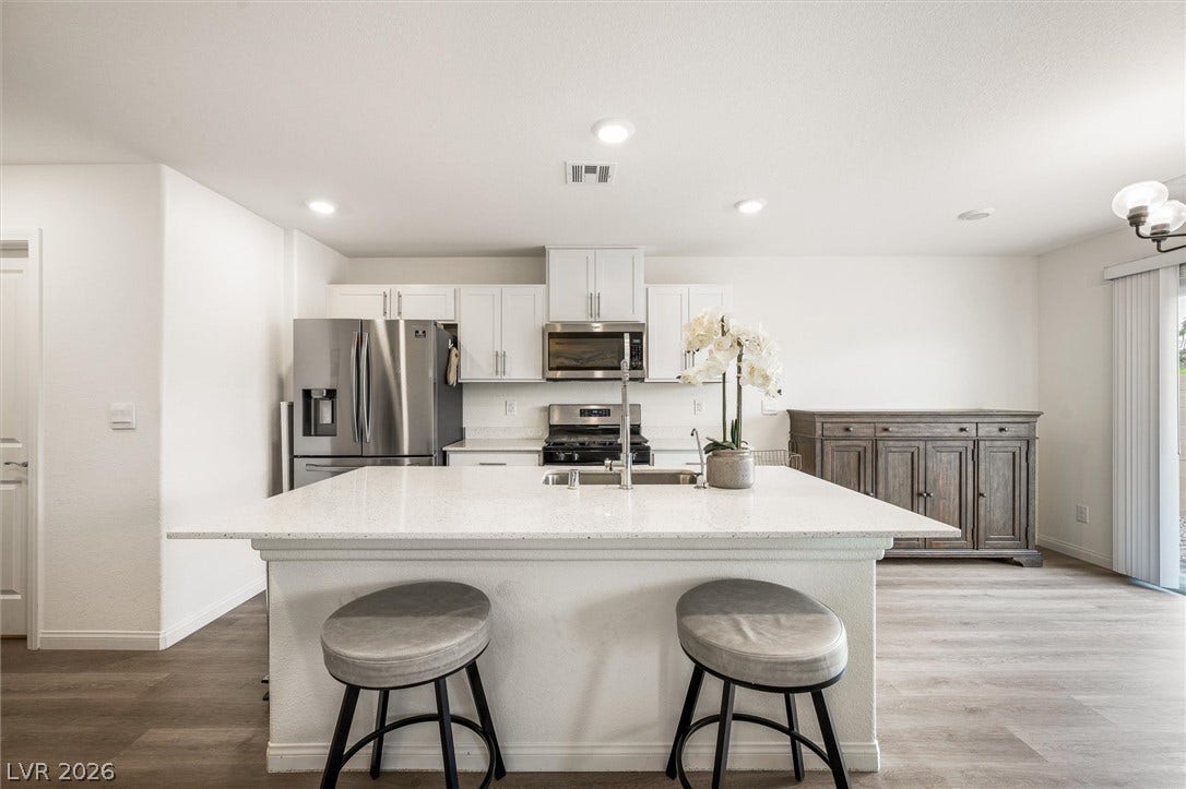 5651 Scarlet Rock Street, North Las Vegas, NV 89081 Smooth stone countertops and crisp cabinetry anchor a modern workspace built around a central island.