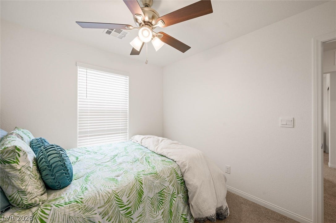 5651 Scarlet Rock Street, North Las Vegas, NV 89081 Plush carpeted flooring and a large window define this inviting bedroom space.